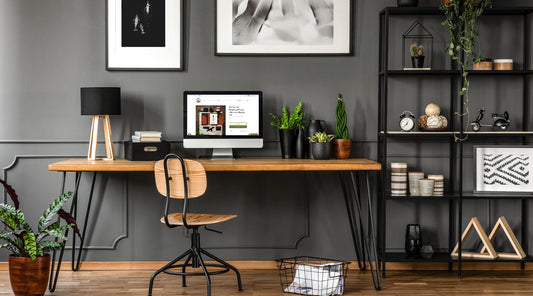 Well organised minimalistic office space with warm tones, wood furniture and art on the walls.